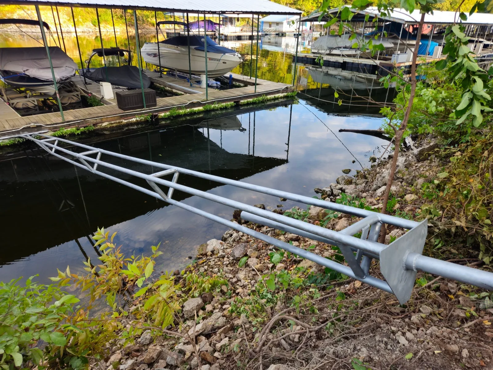 Boat-lift stiff arm extending from a dock