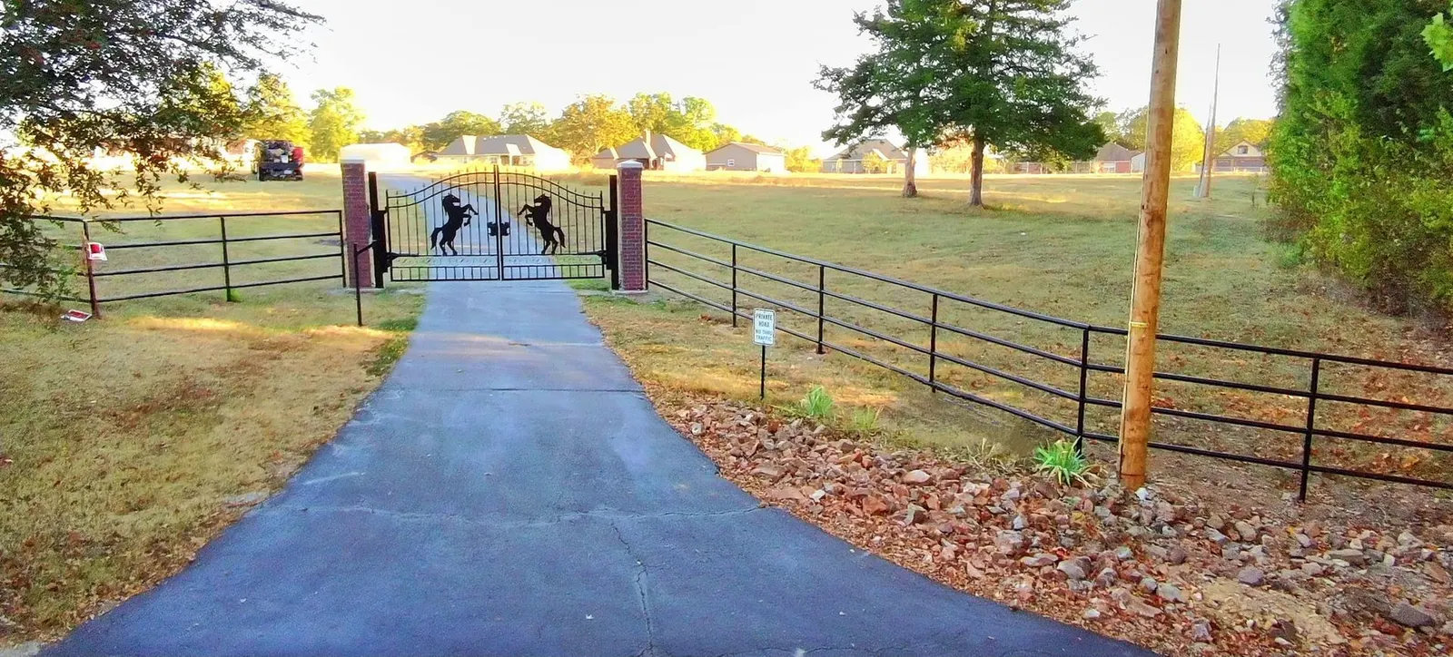 Pipe fence with dual metal driveway gates