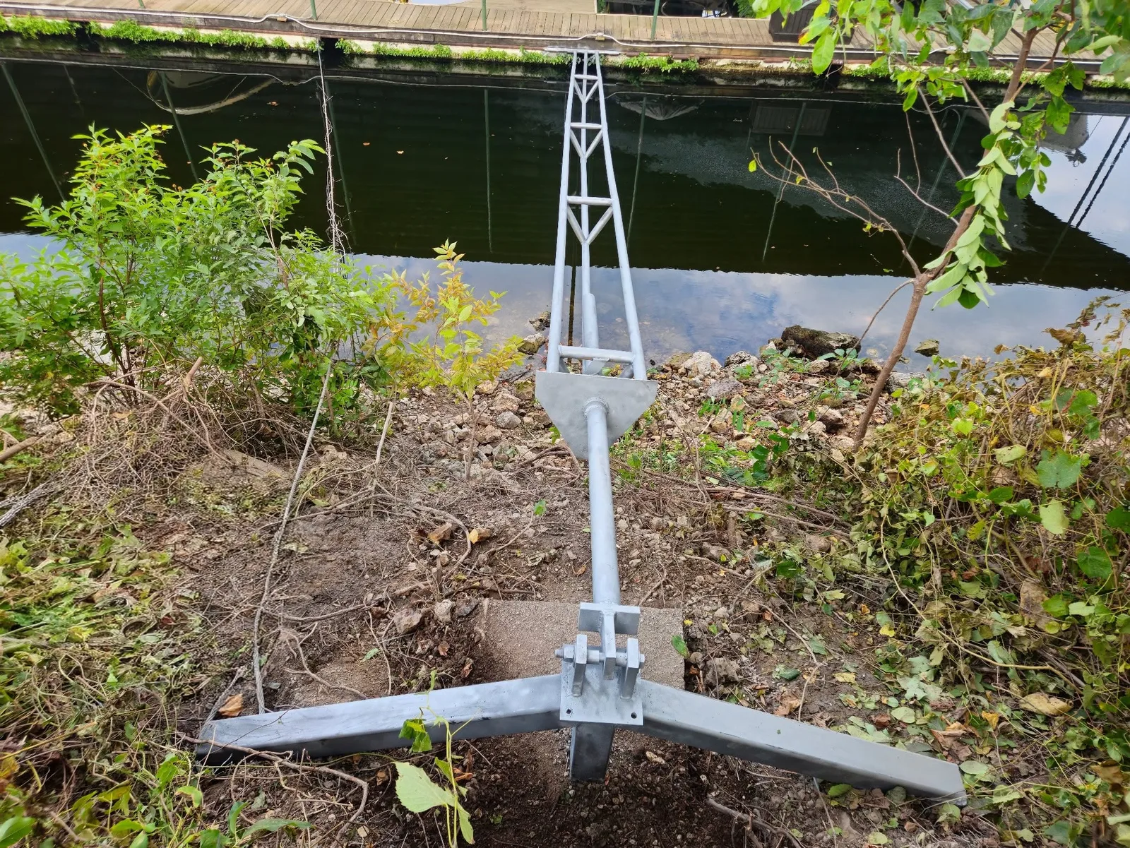 Welded stiff-arm assembly connected to a lakefront dock