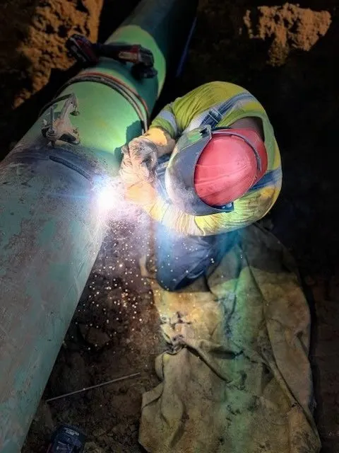 Welder working on a large industrial pipe